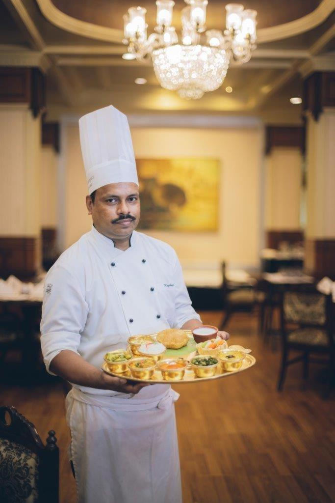 瓦拉纳西泰姬恒河酒店 外观 照片 A chef with a selection of Indian snacks
